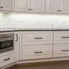 A kitchen with white cabinets and drawers