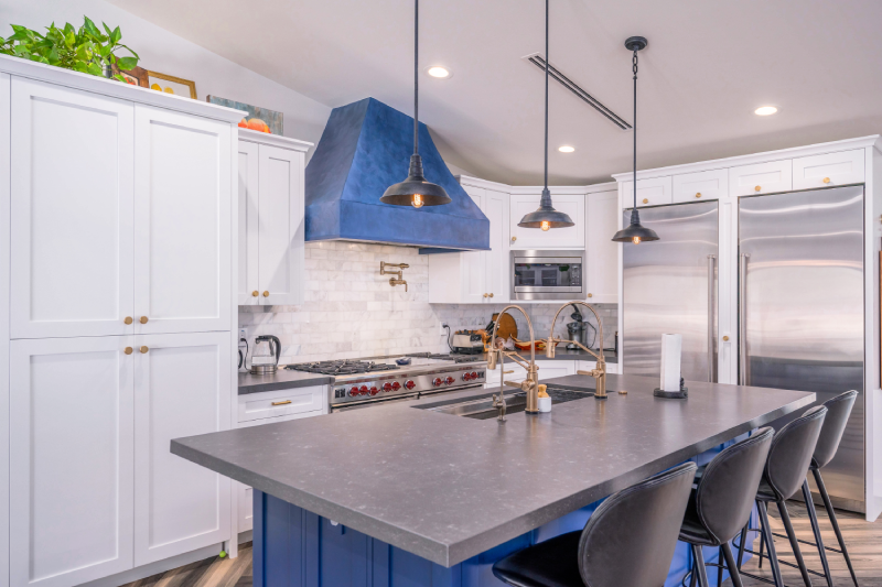 A kitchen with blue cabinets and white walls.