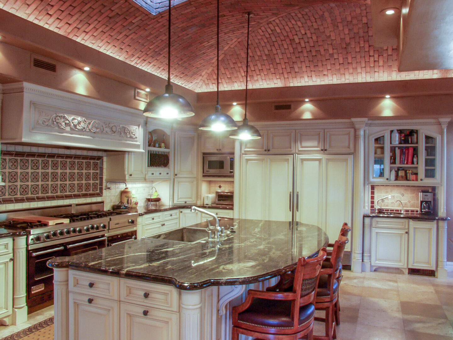 A kitchen with a large island and many lights.