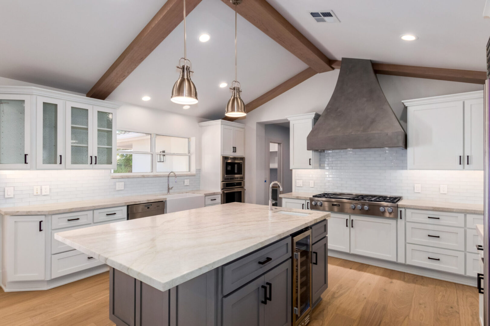 A large kitchen with an island and white cabinets.