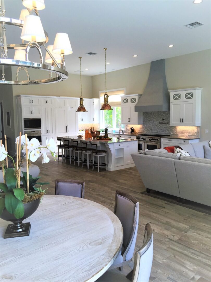 A dining room table and chairs in front of a kitchen.