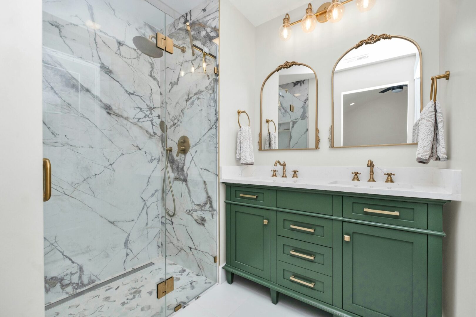 A bathroom with green cabinets and marble walls.