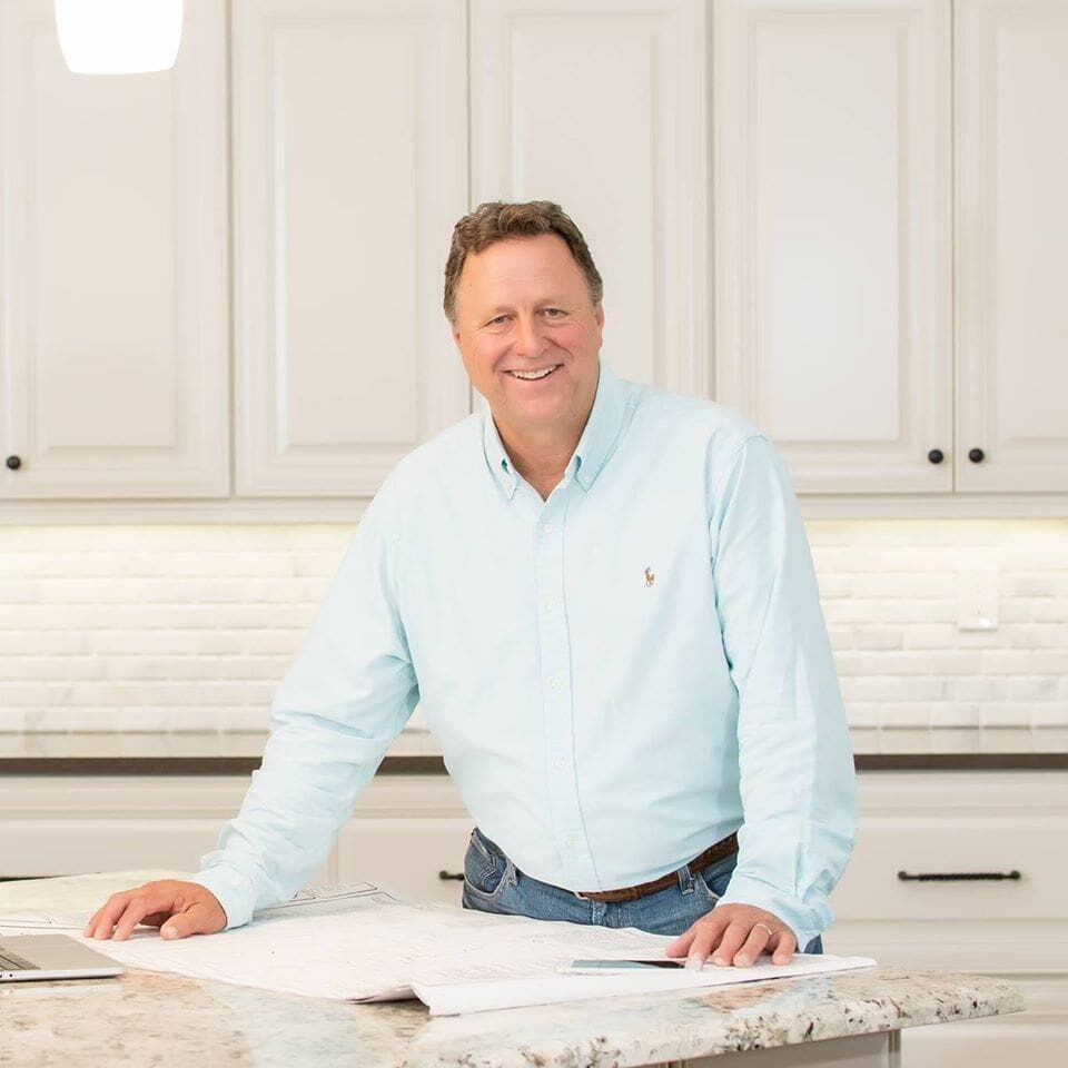 A man sitting at the counter of a kitchen.